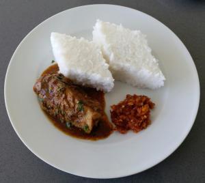 a white plate of food with rice and meat at Sampath Grand Hotel in Mawanella