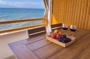 a table with a bowl of fruit and two glasses of wine at Lighthouse in Kallirákhi