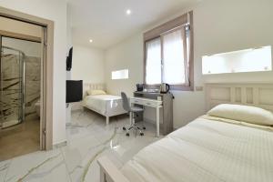 a bedroom with two beds and a desk and a computer at Gioia e Relax di ZR in Rho