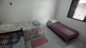a small bedroom with a bed and a window at Casa Próxima ao Centro in Itajubá +2 photos
