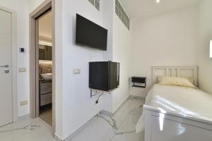 a bedroom with a bed and a tv on the wall at Gioia e Relax di ZR in Rho