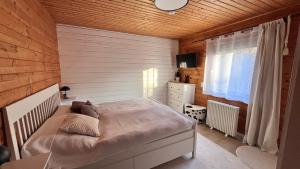 a bedroom with a bed and a wooden wall at Ferienhaus Waldliebe in Grafenau