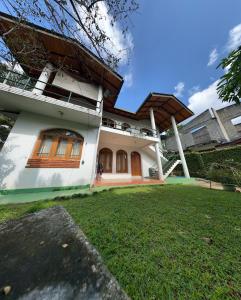 a house with a green lawn in front of it at Johannes Nest in Gampola