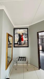 a picture of a couple with an umbrella in a room at Dakarai B & B in Thulamahashi