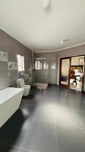 a bathroom with a tub and a toilet and a sink at Dakarai B & B in Thulamahashi +96 photos