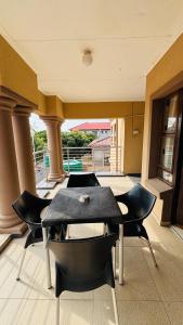 a room with a table and chairs on a balcony at Dakarai B & B in Thulamahashi