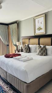 a large bed in a hotel room with a large white bed at Dakarai B & B in Thulamahashi