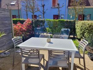 a white table and chairs on a patio at Villa Chez Laurette - Baie de Somme en famille - 4 à 6 personnes - piscine - parking privé - plage à 5 min in Le Crotoy