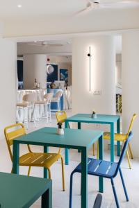 two tables and chairs in a room with a restaurant at Noera in Skiathos