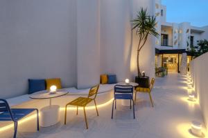 a room with two tables and chairs with lights at Noera in Skiathos