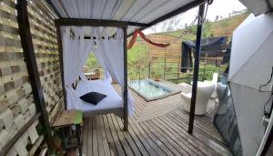 a porch with a swing and a hot tub at Glamping Paraiso in San Roque