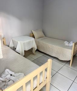 a room with two beds and a table and a bed at Hotel empresarial HARRY WORLD in Curitibanos