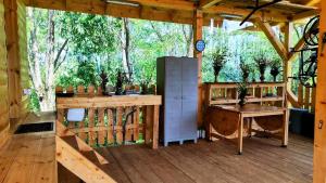a porch of a wooden cabin with a desk and a table at SkyhighRetezat in Clopotiva