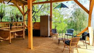 a pavilion with chairs and a table on a wooden deck at SkyhighRetezat in Clopotiva