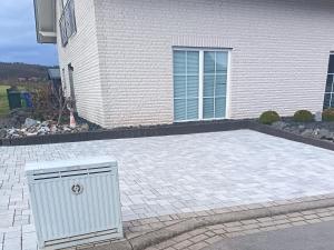 a white appliance sitting on a patio in front of a house at Ferienwohnung Röddenau in Röddenau +5 photos