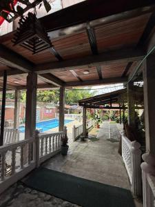 a covered porch with a pool in the background at La morada in Guayabal