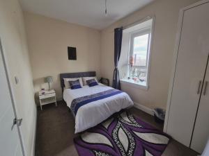 a bedroom with a bed and a window at Cosy and Bright 3-bedroom flat in Glasgow
