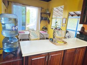 a kitchen with a large bottle of water on the counter at The Howler Jungle House and Cabanas in Belize City +28 photos