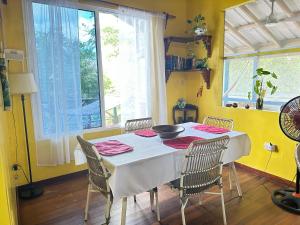 a dining room with a white table and chairs at The Howler Jungle House and Cabanas in Belize City