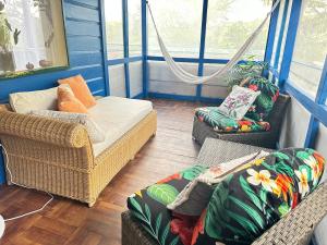 a living room with two chairs and a couch at The Howler Jungle House and Cabanas in Belize City