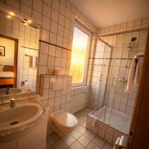 a bathroom with a sink and a toilet and a shower at Hotel Bölke in Wunstorf +31 photos