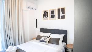 a bedroom with a bed with white sheets and pillows at Basil Leaf - Minimal View Retreat in Gonia
