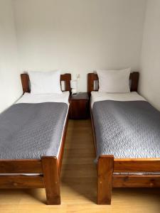 two beds sitting next to each other in a room at Domki Magnolia - komfortowe domki dla rodzin nad morzem in Dźwirzyno