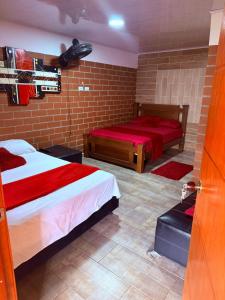 a bedroom with two beds and a brick wall at La morada in Guayabal