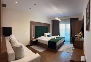 a bedroom with a bed and a couch at MCity Hotel in Arad