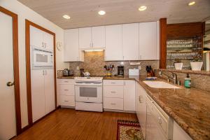 a kitchen with white cabinets and a sink at Star Harbor # 13 By Hauserman Rentals in Tahoe City