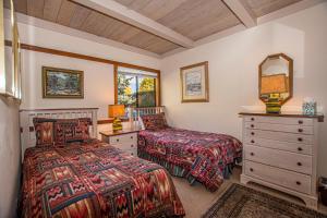 a bedroom with two beds and a dresser and a mirror at Star Harbor # 13 By Hauserman Rentals in Tahoe City +34 photos