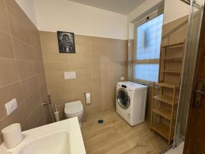 a bathroom with a washing machine next to a toilet at CAERE RoGi House in Cerveteri +34 photos