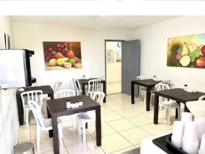 a dining room with tables and chairs and paintings at Hotel Lords in Brasília +10 photos