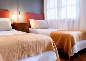 two beds in a hotel room with a window at Moreno 820 by DOT Suites in Buenos Aires