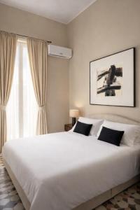 a bedroom with a large white bed and a window at Bari LandLord 71 - Private Balcony Suites in Bari