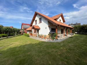 a house with a grassy yard in front of it at AchKaszuby domki nad morzem in Puck