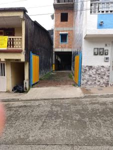 an empty alley with yellow doors on a building at Quindio Mio in Filandia