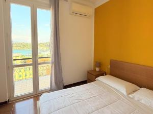 a bedroom with a bed and a large window at Terrazza Portovenere in Le Grazie