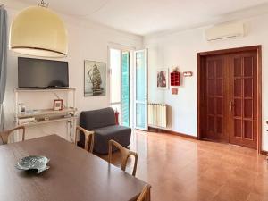 a living room with a table and chairs and a television at Terrazza Portovenere in Le Grazie
