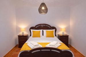 a bedroom with a large bed with yellow pillows at O Cantinho dos Avós in Mourão