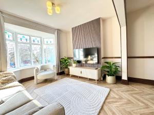 a living room with a couch and a tv at Shrubbery Lodge - Games Room & Patio Dining in Wyke Regis