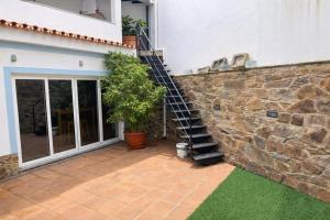 a stone wall with a staircase next to a house at O Cantinho dos Avós in Mourão