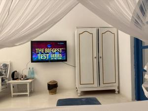 a bedroom with a tv on the wall next to a cabinet at The Tranquilite' in Anuradhapura