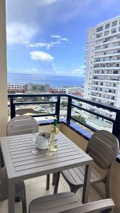 a table and chairs on a balcony with a view of the ocean at Cozy Ocean view 1 BDR APT, Club Paraiso in Playa Paraiso