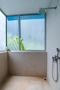 a bathroom with a shower with a large window at La Villetta in Ostional +15 photos