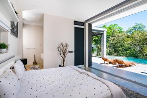 a bedroom with a bed and a view of a pool at La Villetta in Ostional