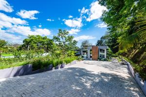 a driveway leading to a house with trees at La Villetta in Ostional