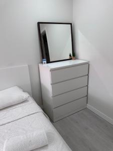 a bedroom with a dresser with a mirror and a bed at Rooms Moscavide quartos in Lisbon