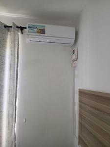 a white air conditioner in a white room at Kimbar Suites in Mombasa +1 photo