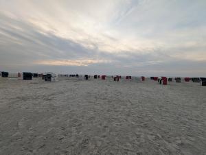 a group of chairs sitting on the beach at Haus Ausreißer 2 - Hafennest in Bensersiel